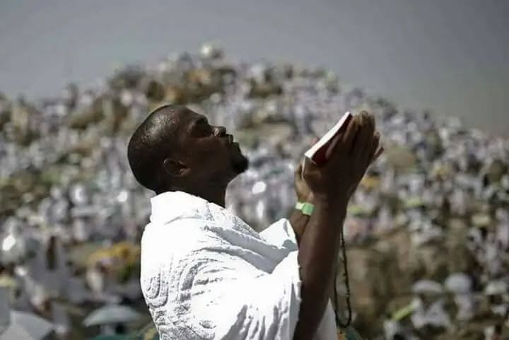 Pèlerin en invocation, le regard levé, au milieu de la foule